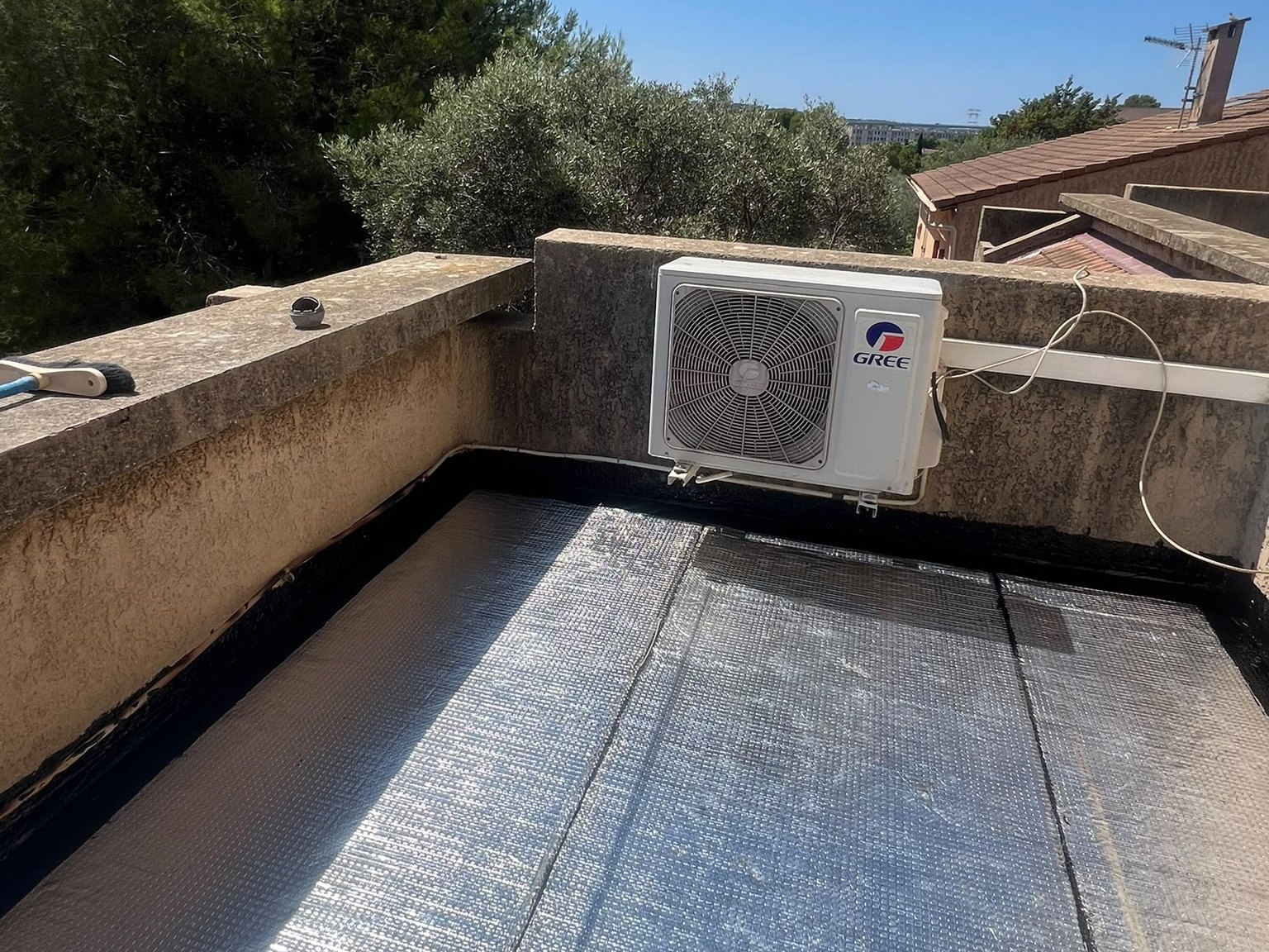 Terrasse couverte d’une membrane d’étanchéité à face aluminium, relevée le long des murets