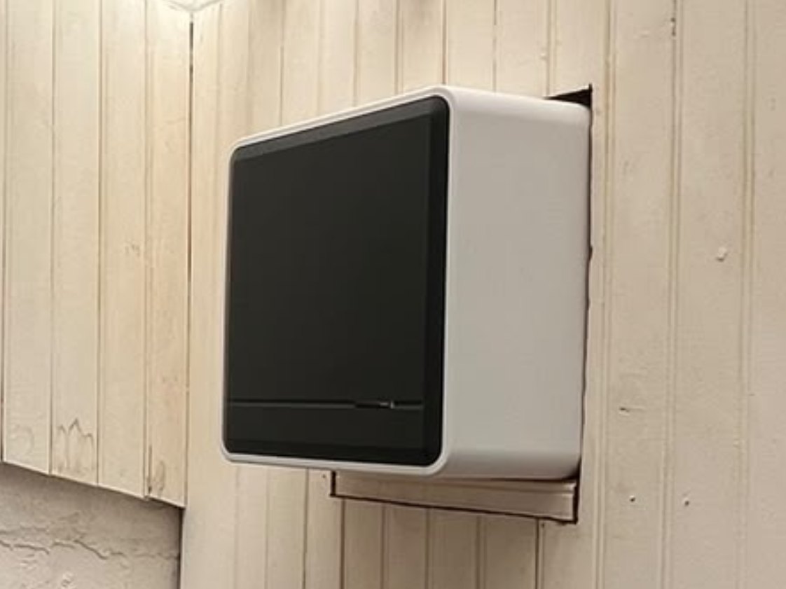 Appareil de ventilation fixé au mur d’une pièce lambrissée